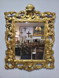 Espejo dorado isabelino con marco tallado y penacho superior, pieza decorativa del siglo XIX para espacios con estilo vintage y sofisticado.