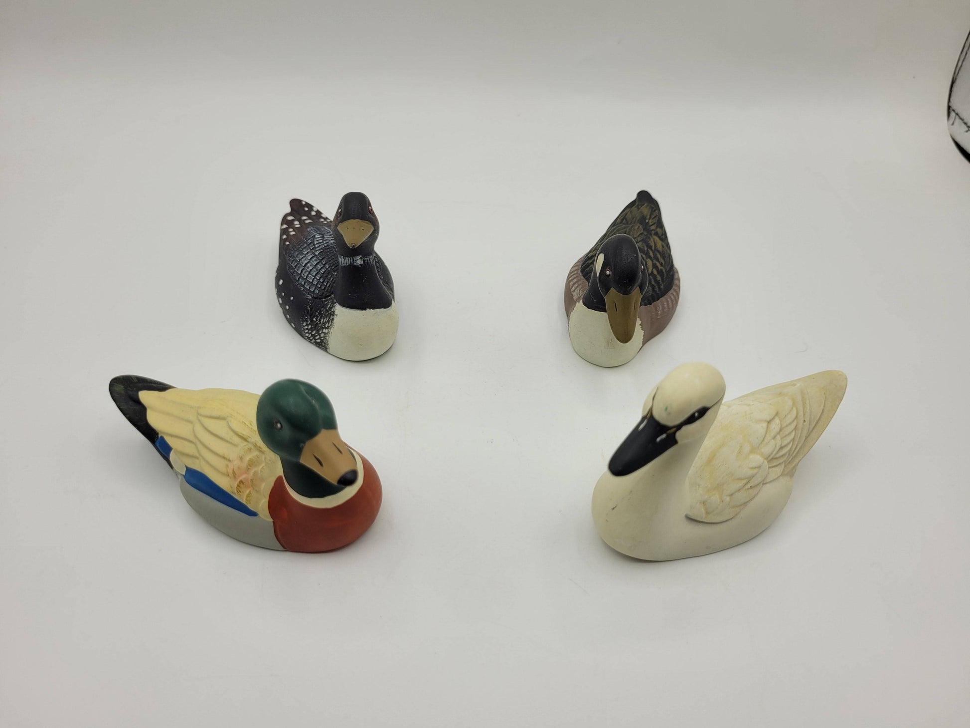 Set de 4 patos de porcelana dispuestos en forma circular, ideales para coleccionistas y decoración de interiores. Medidas 10x6cm.