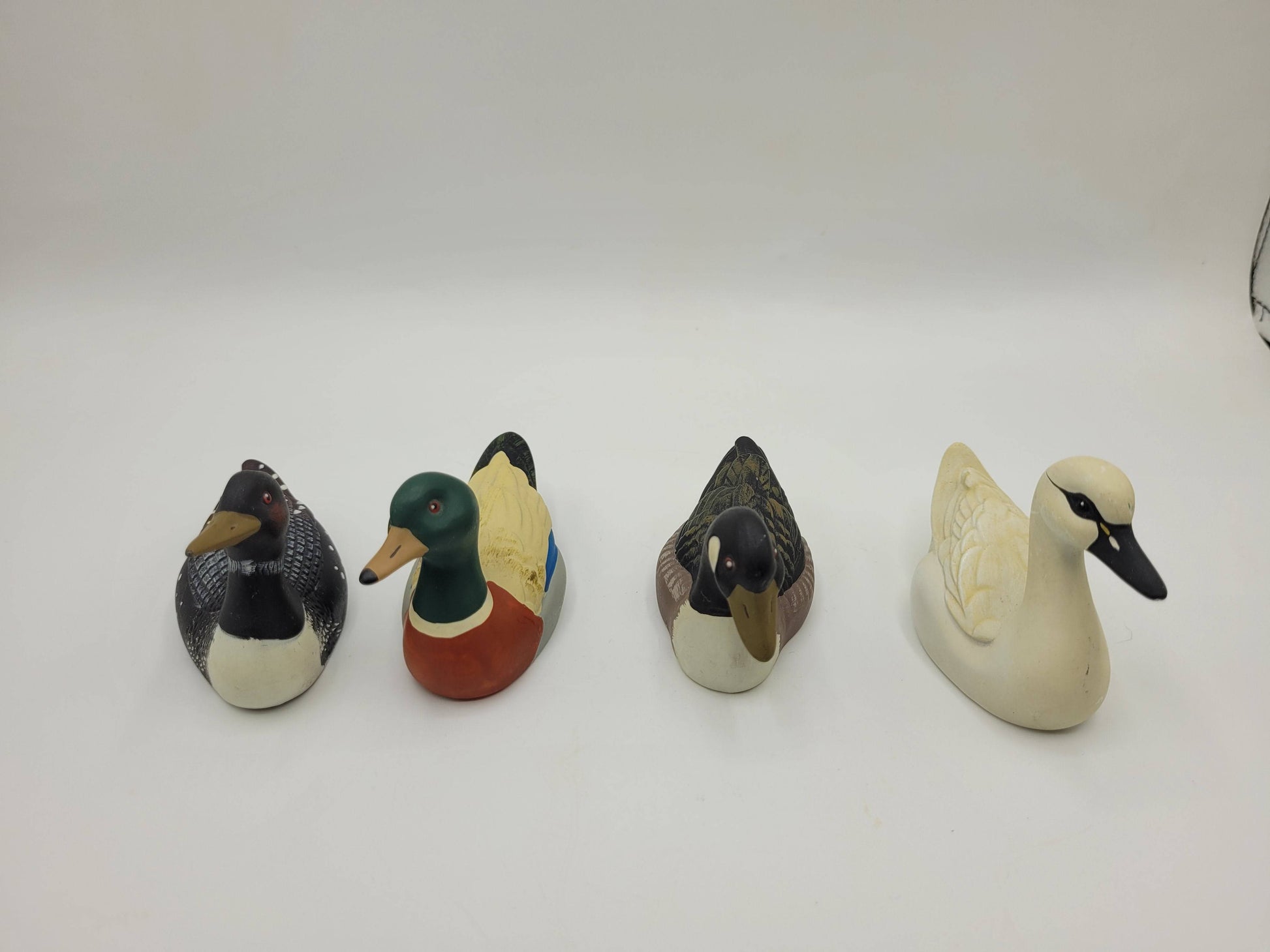 Patos de porcelana alineados mostrando sus detalles frontales. Colección de 4 piezas únicas para decoración de hogar y jardín.