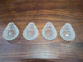 Cuatro conchas bautismales de cristal antiguo alineadas simétricamente, perfectas para decoración vintage en el hogar o eventos religiosos.