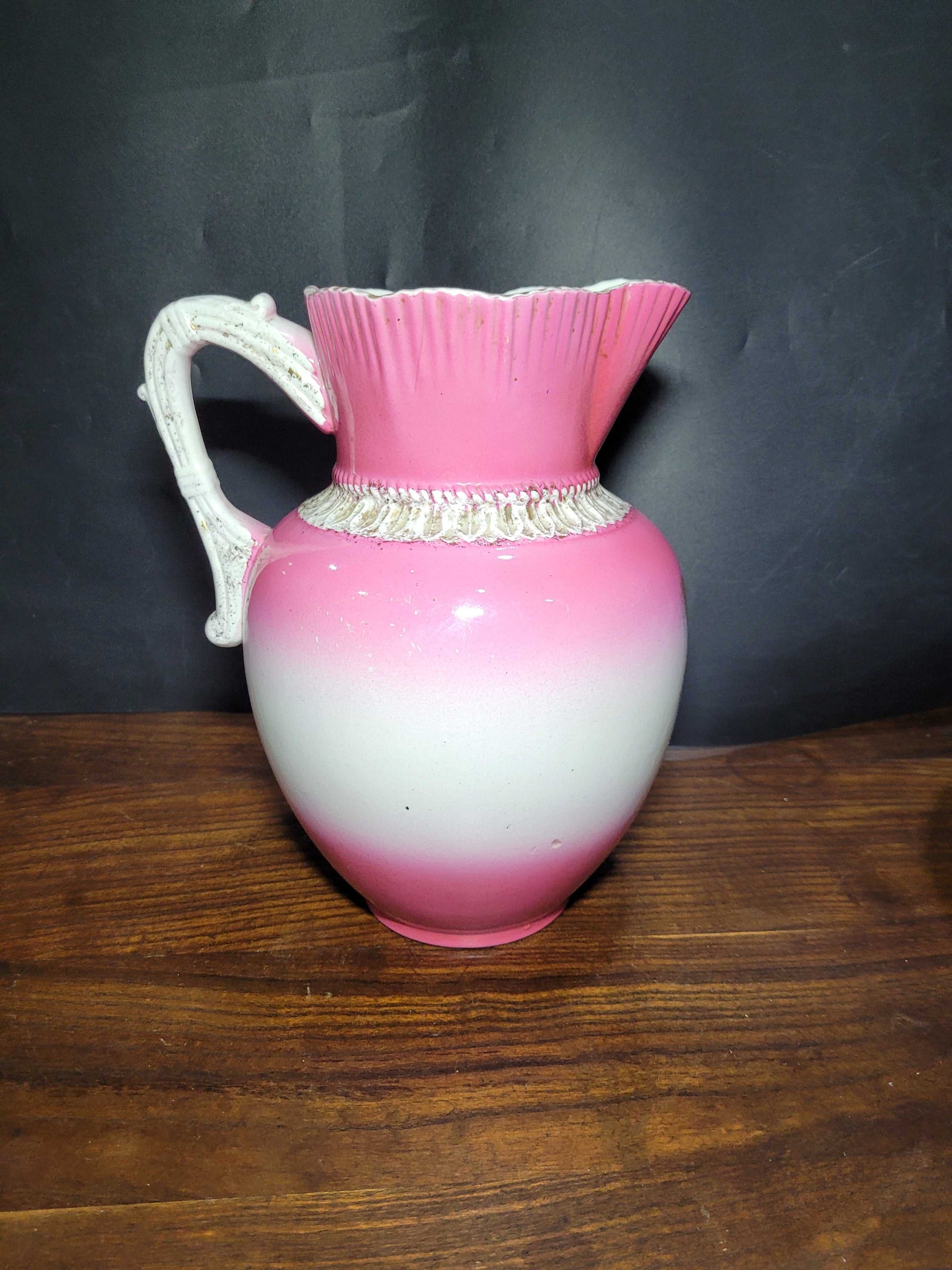 Jarra de porcelana de Sevilla siglo XIX con diseño degradado en rosa y blanco, asa ornamentada y detalles clásicos. Ideal para decoración vintage.