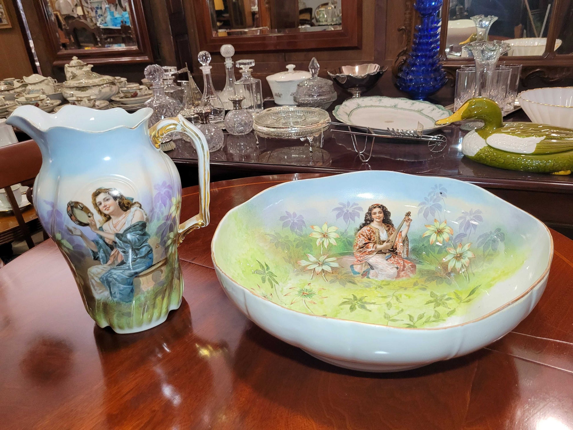 Conjunto de aguamanil de porcelana Limoges del siglo XIX pintado a mano, con jarra y palangana decoradas con escenas románticas y detalles florales.