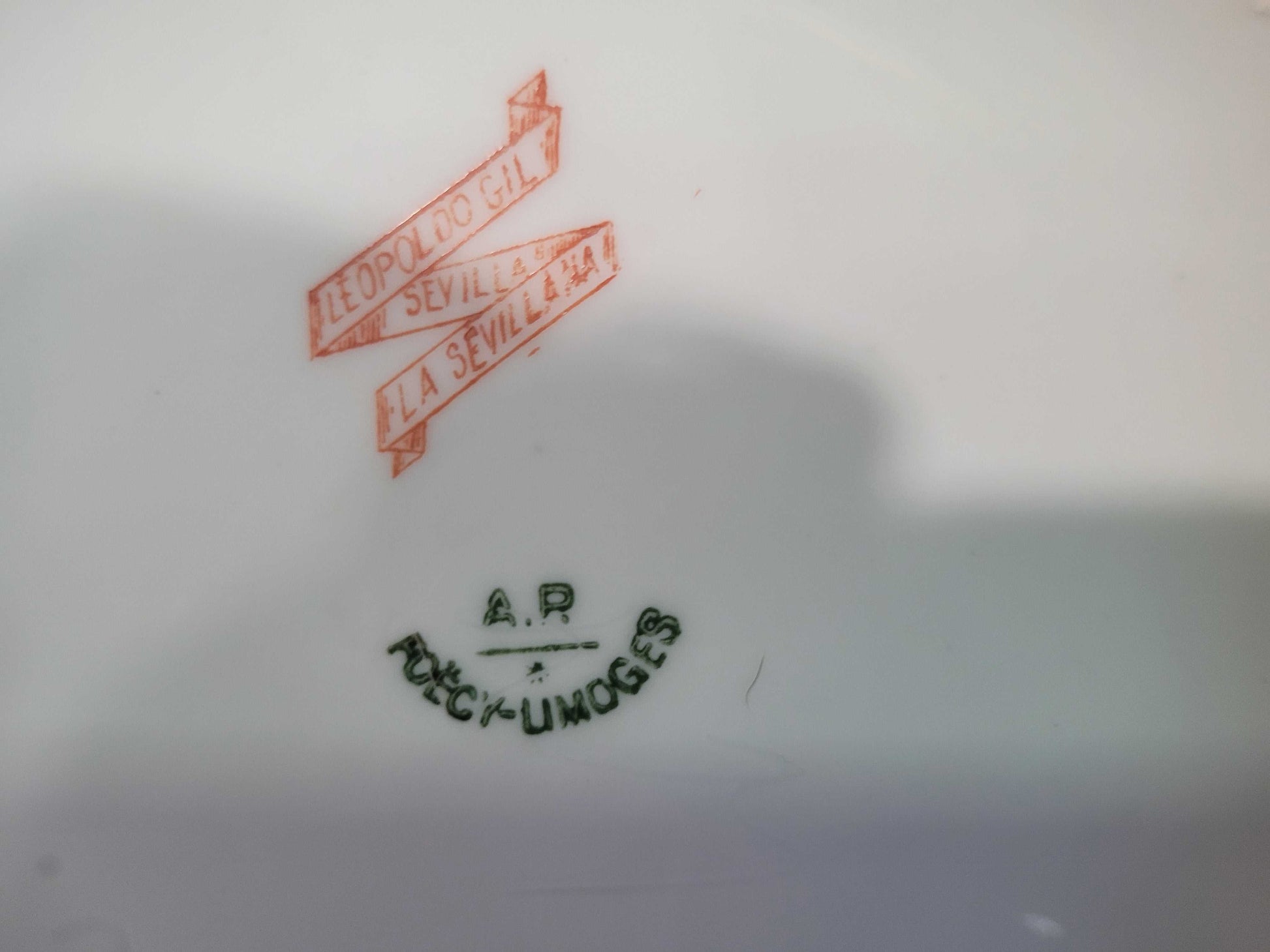 Sello de autenticidad en la base del aguamanil de porcelana Limoges del siglo XIX, con marcas de fábrica y distribuidor, ideal para coleccionistas de decoración.