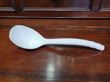 Cucharón de porcelana blanca sobre fondo neutro