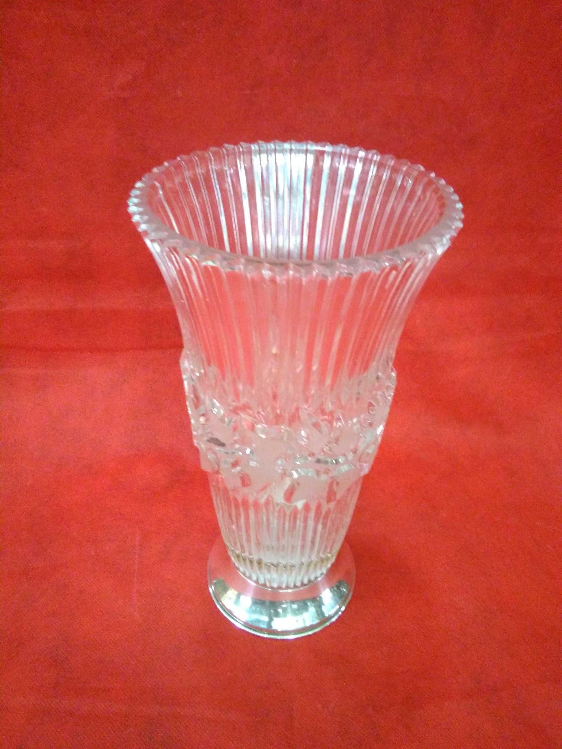 Florero de cristal con base de plata de alta calidad sobre fondo rojo, ideal para decoración elegante en el hogar. Diseño clásico con detalles tallados.
