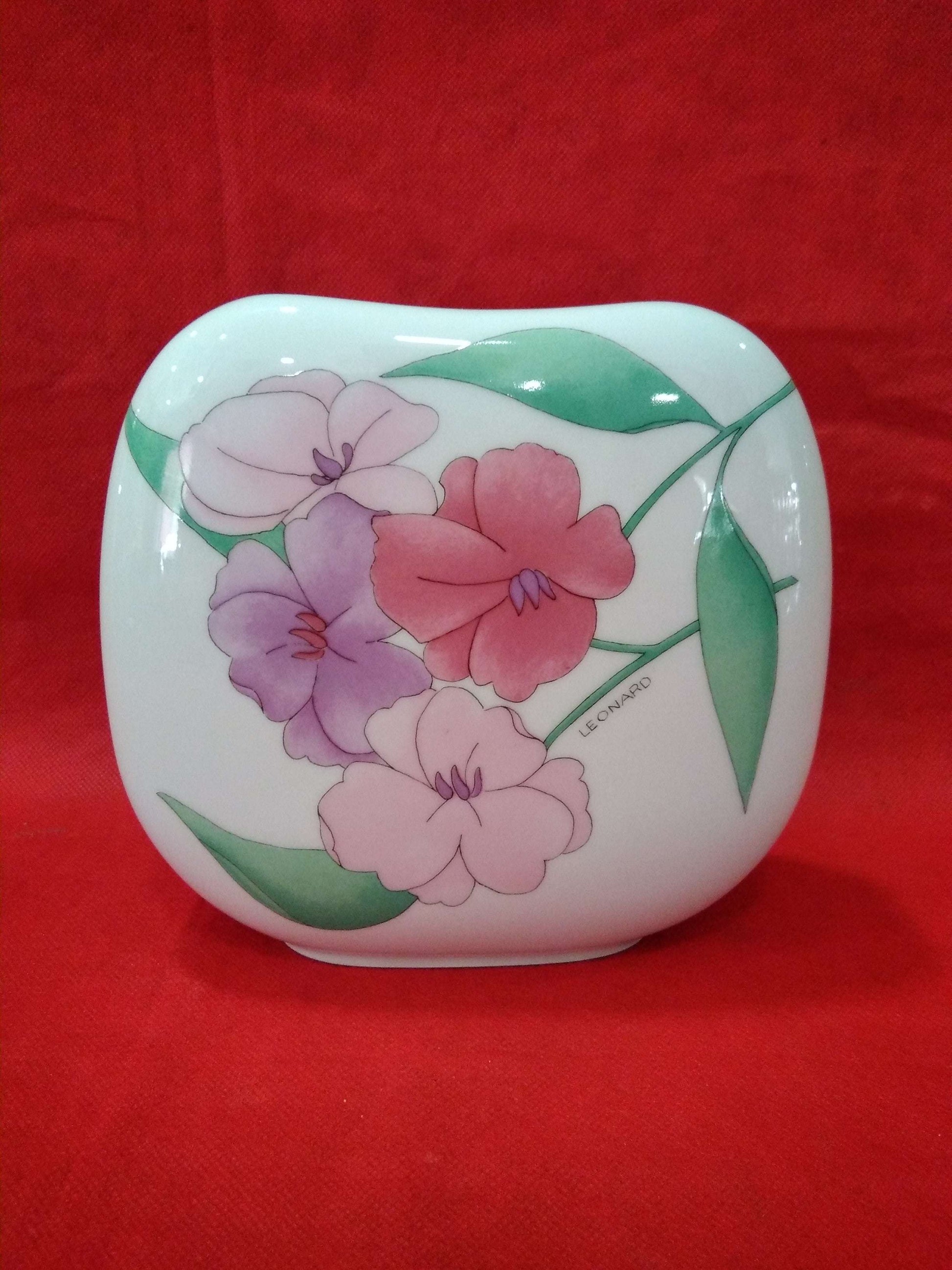 Jarrón de porcelana con diseño floral pintado a mano en tonos pastel, ideal para decoración elegante en el hogar. Calidad superior y estilo clásico.