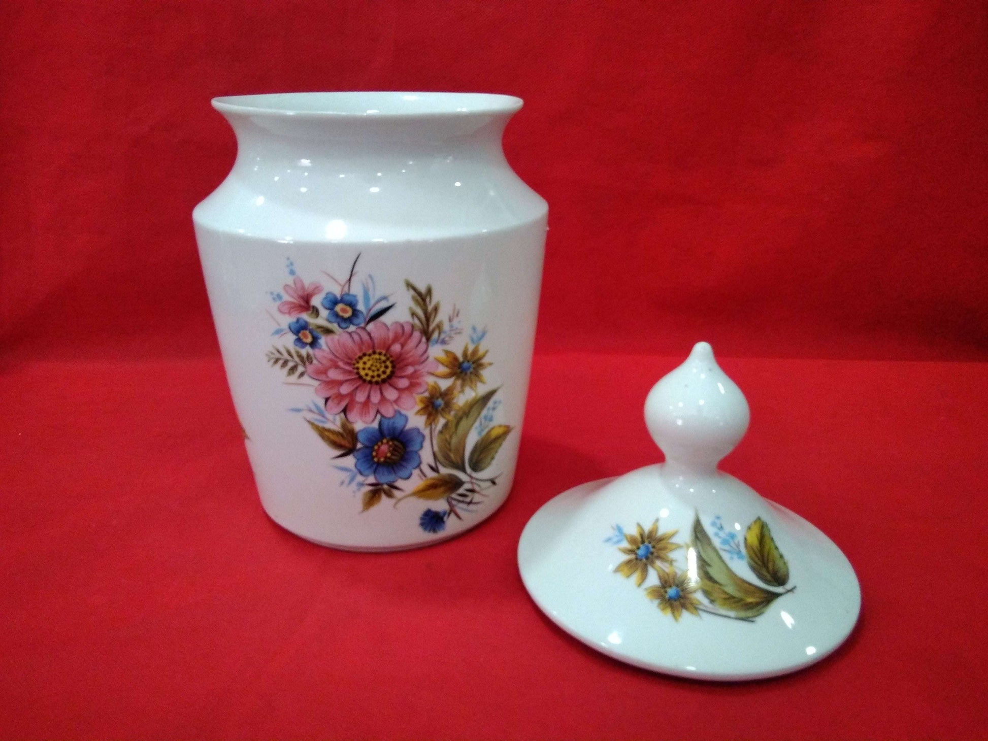 Tibor de porcelana de excelente calidad con diseño floral pintado a mano, ideal para decoración clásica en el hogar. Incluye tapa removible a juego.