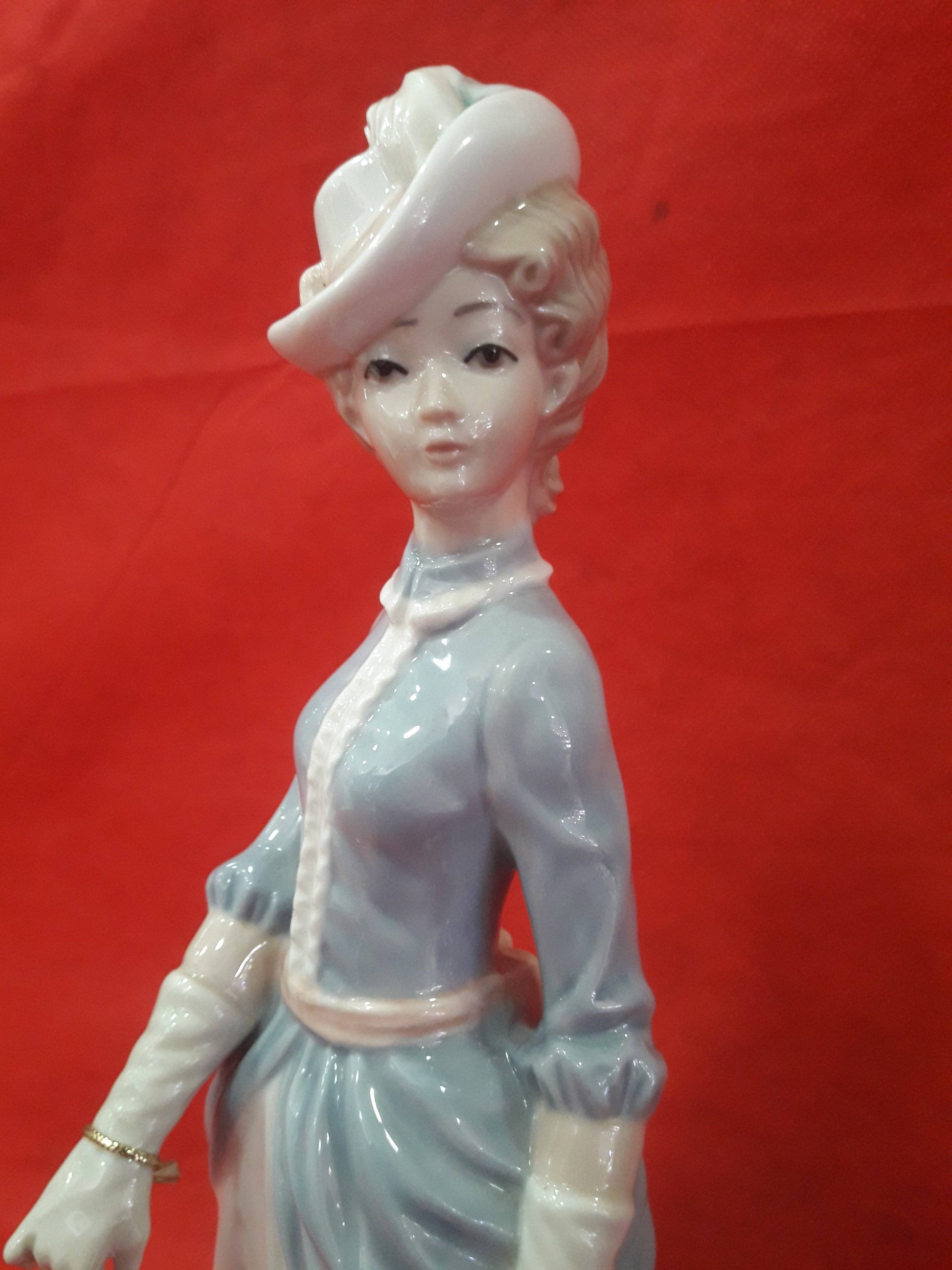 Detalle del rostro y vestimenta de la figura Mujer con perro | Porcelana Española Tengra, mostrando la delicada artesanía y acabado brillante.