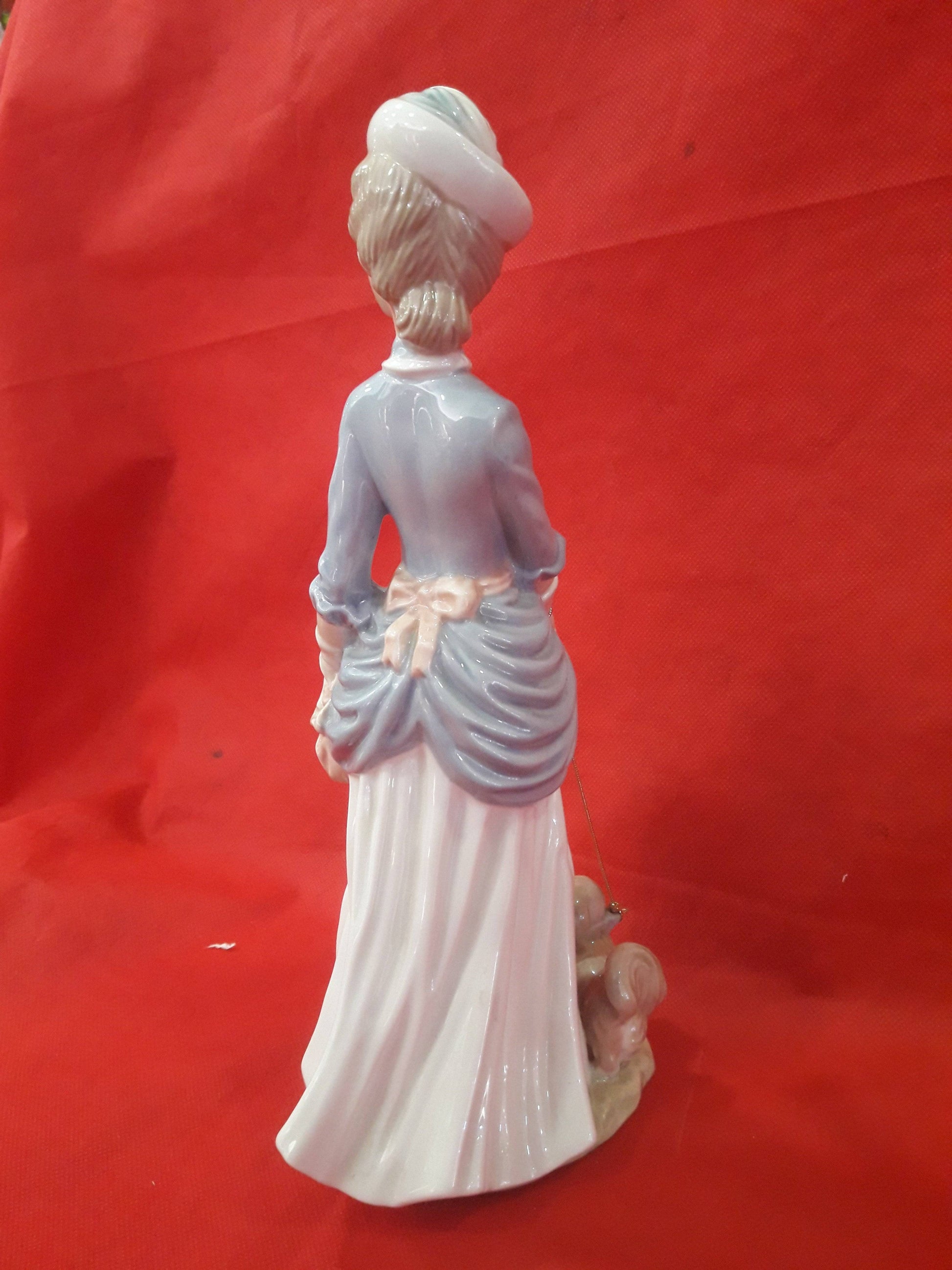 Vista trasera de la figura Mujer con perro | Porcelana Española Tengra, destacando el moño y pliegues del vestido en porcelana esmaltada.