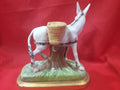 Vista trasera de figura de burro de porcelana con alforjas, diseño detallado y acabado clásico. Perfecto para coleccionistas.