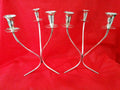 Pareja de candelabros de alpaca de 33 cm con diseño curvo y elegante sobre fondo rojo. Decoración ideal para espacios sofisticados y modernos.
