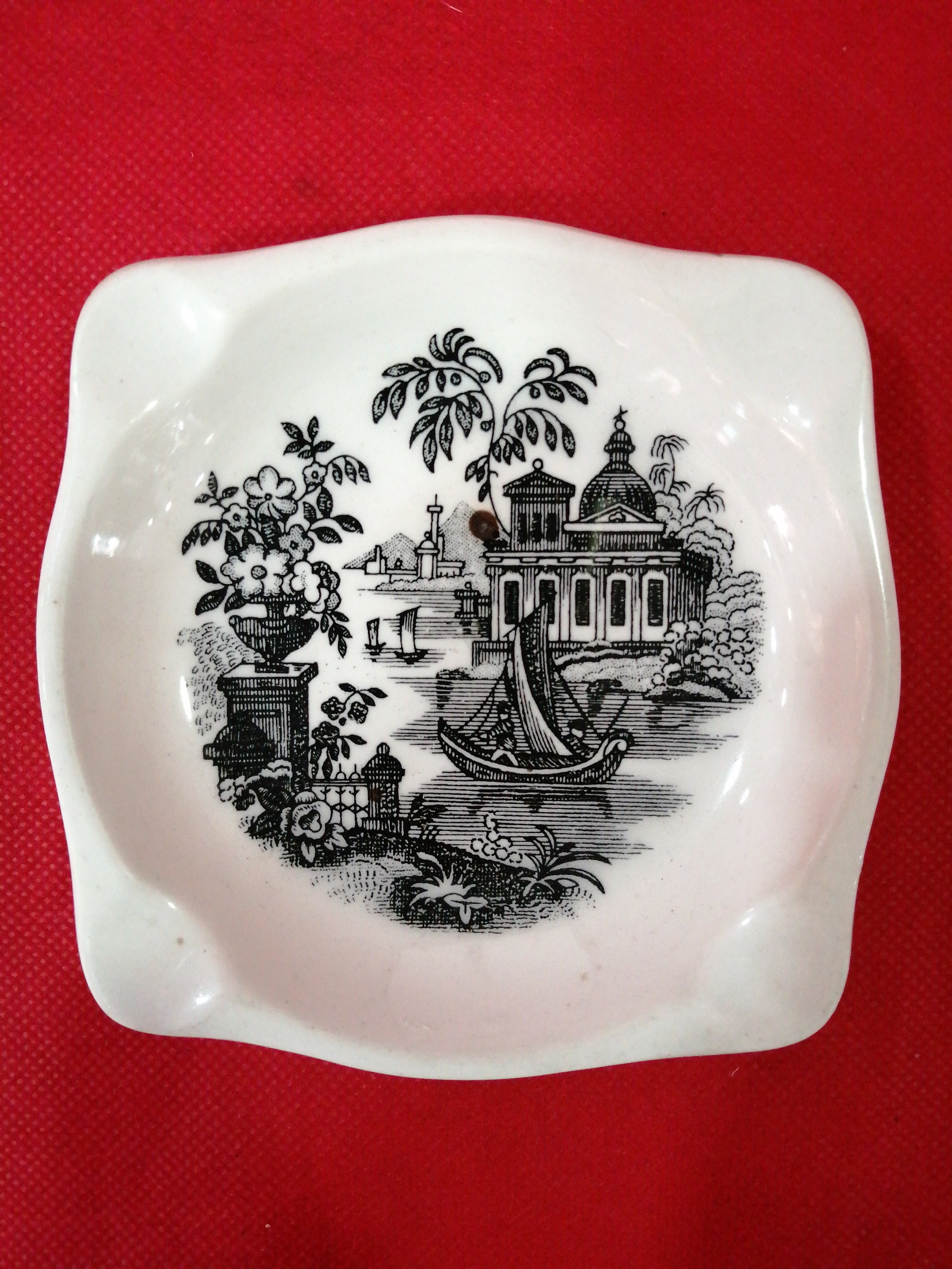 Cenicero de porcelana de La Cartuja con diseño clásico en blanco y negro, decorado con paisajes y detalles vintage, ideal para decoración.