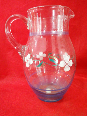 Jarra de cristal antigua decorada a mano con flores blancas y hojas verdes sobre fondo rojo. Ideal para decoración vintage en el hogar.