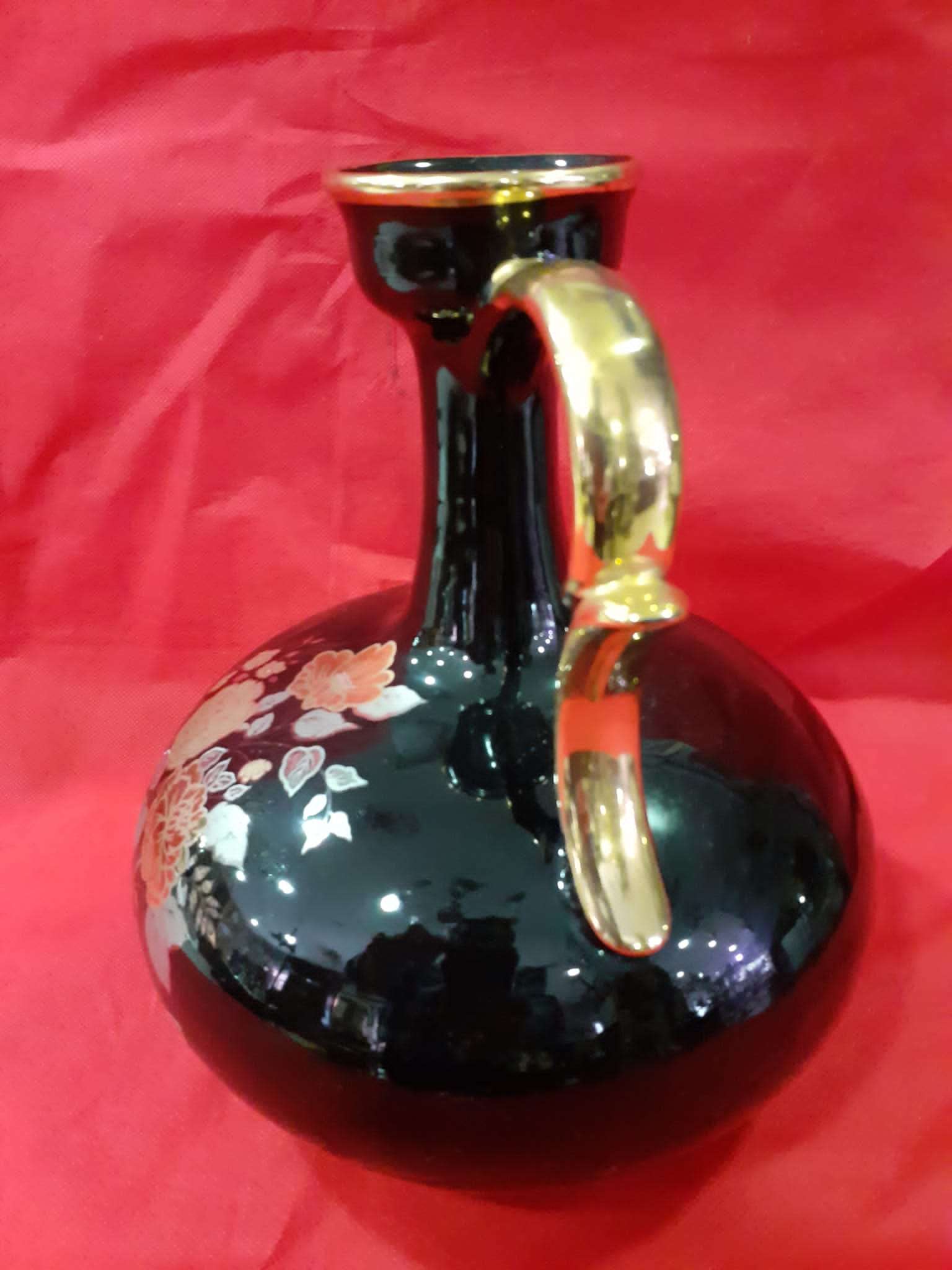 Jarrón de porcelana de excelentes calidades para el hogar con acabado negro brillante, detalles florales pintados y asa dorada elegante. Ideal para decoración de interiores en espacios clásicos o modernos.