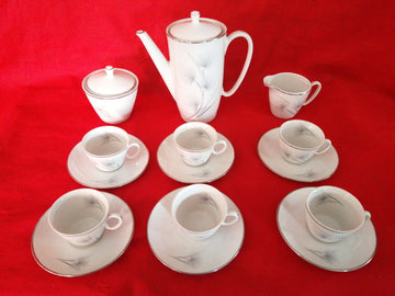Juego de café porcelana Santa Clara 6 servicios con diseño elegante sobre fondo rojo. Ideal para decoración clásica en el hogar.