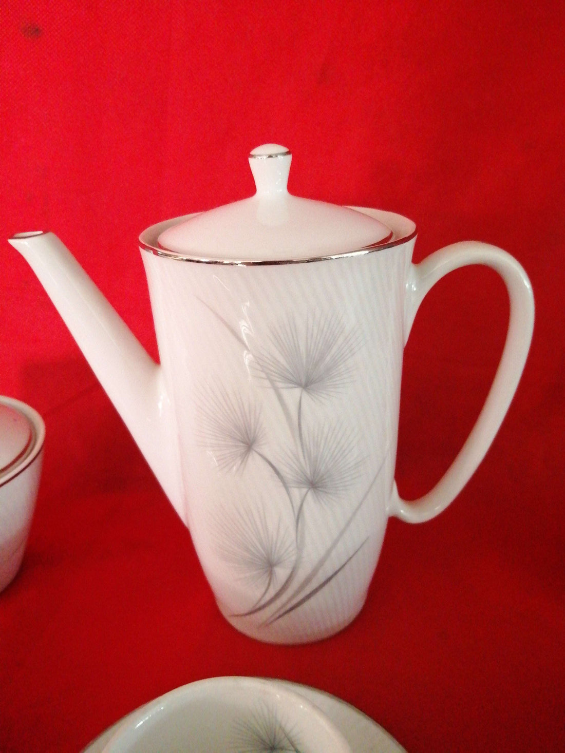 Juego de café porcelana Santa Clara 6 servicios con diseño elegante sobre fondo rojo. Ideal para decoración clásica en el hogar.