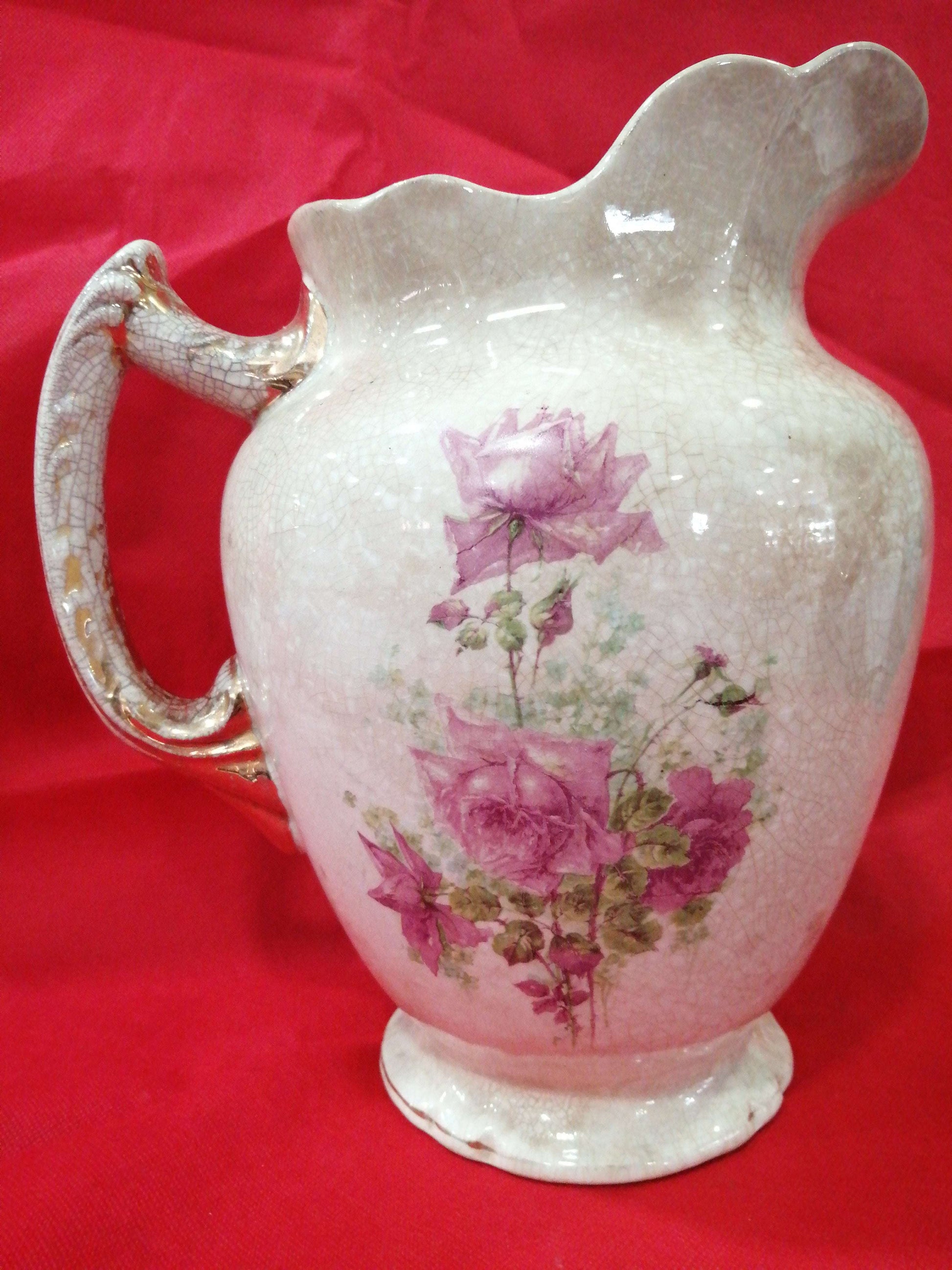 Jarra antigua de palanganero pintada a mano con flores rosas sobre porcelana craquelada. Pieza decorativa de excelente calidad para el hogar.