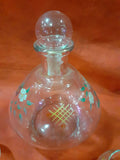 Botella licorera pintada a mano con detalles florales y diseño geométrico, ideal para decoración de hogar y servir licores en ocasiones especiales.