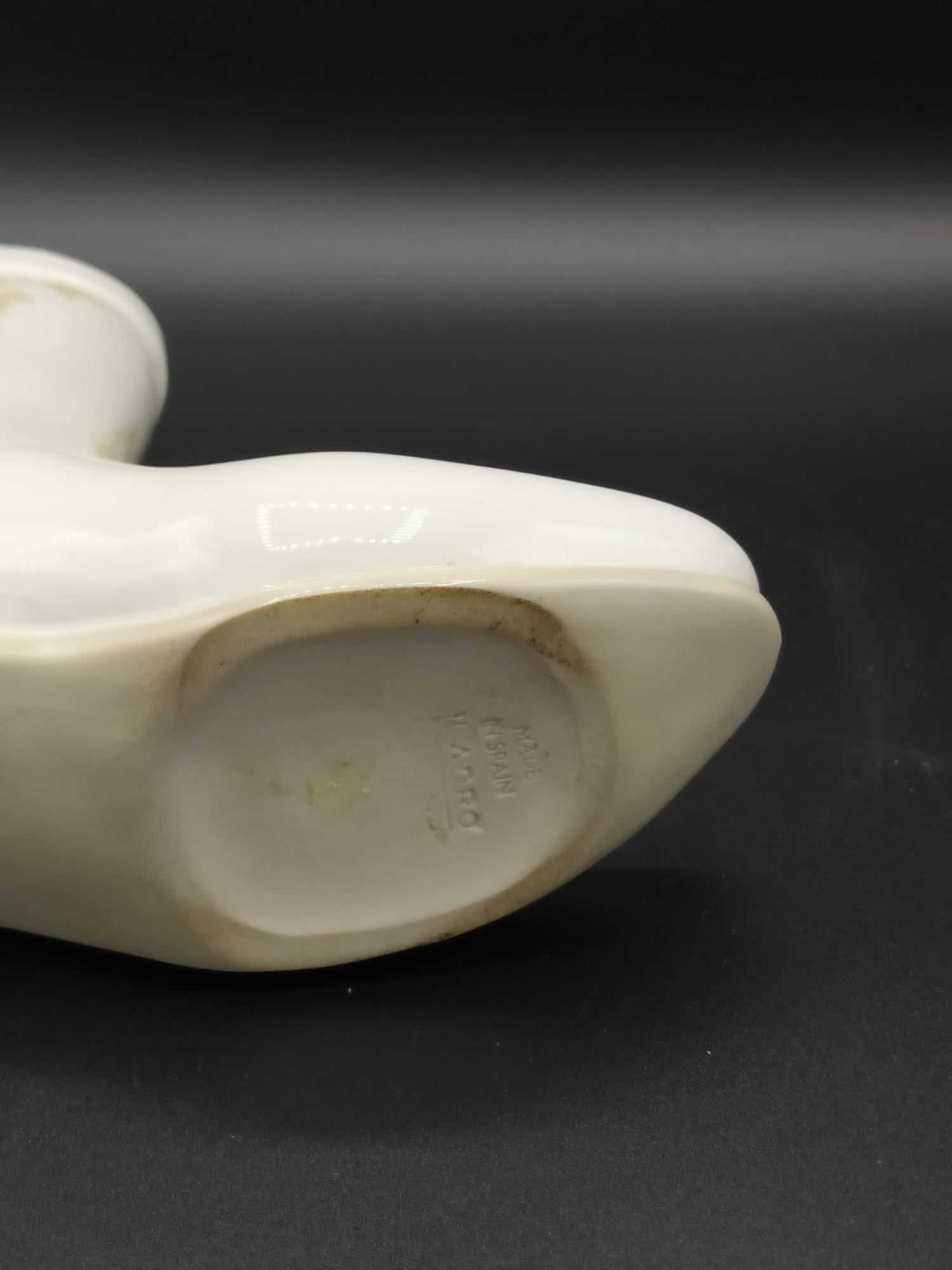 Base de la figura de porcelana Lladró en forma de bota campera, mostrando el sello original que certifica su autenticidad y origen artesanal.