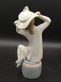 Parte posterior de la figura Lladró 'Chica con gorro', con detalles suaves en porcelana brillante, ideal para ambientes decorativos refinados.