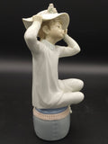 Detalle lateral de la figura Lladró 'Chica con gorro', mostrando el fino acabado artesanal en porcelana, perfecta para coleccionistas de decoración.