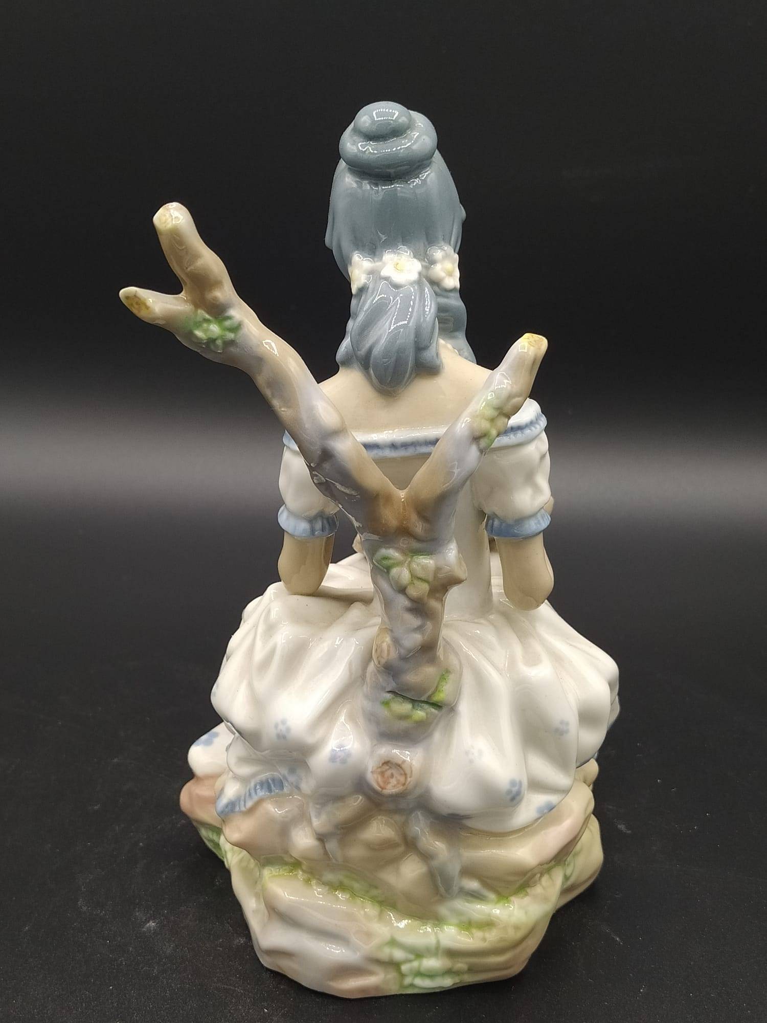 Parte trasera de la figura de porcelana Casades Mujer con Flores, mostrando respaldo en forma de rama y peinado detallado, decoración clásica.