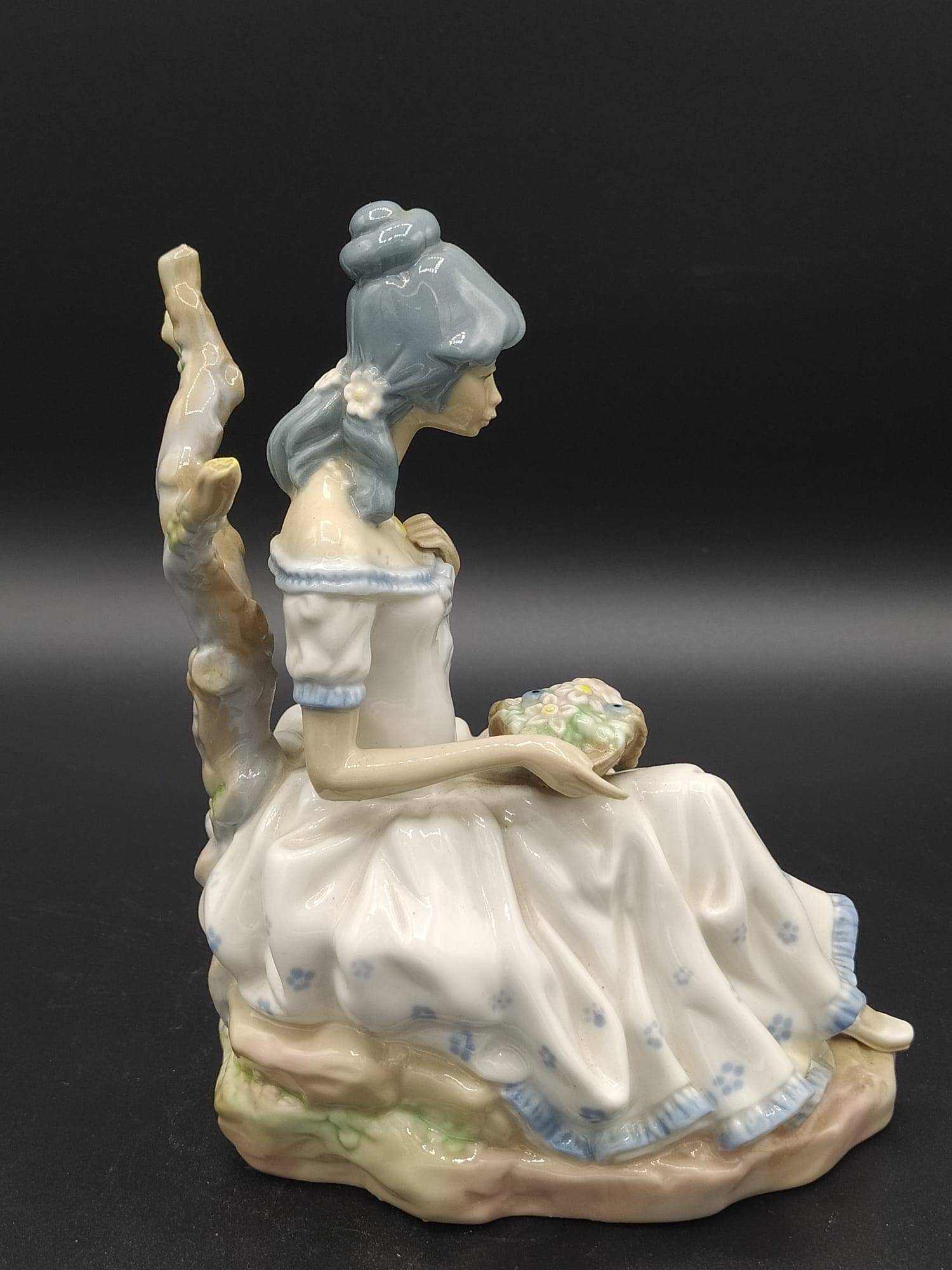 Vista lateral derecha de la figura de porcelana Mujer con Flores de Casades, con acabado brillante y diseño floral en porcelana de alta calidad.