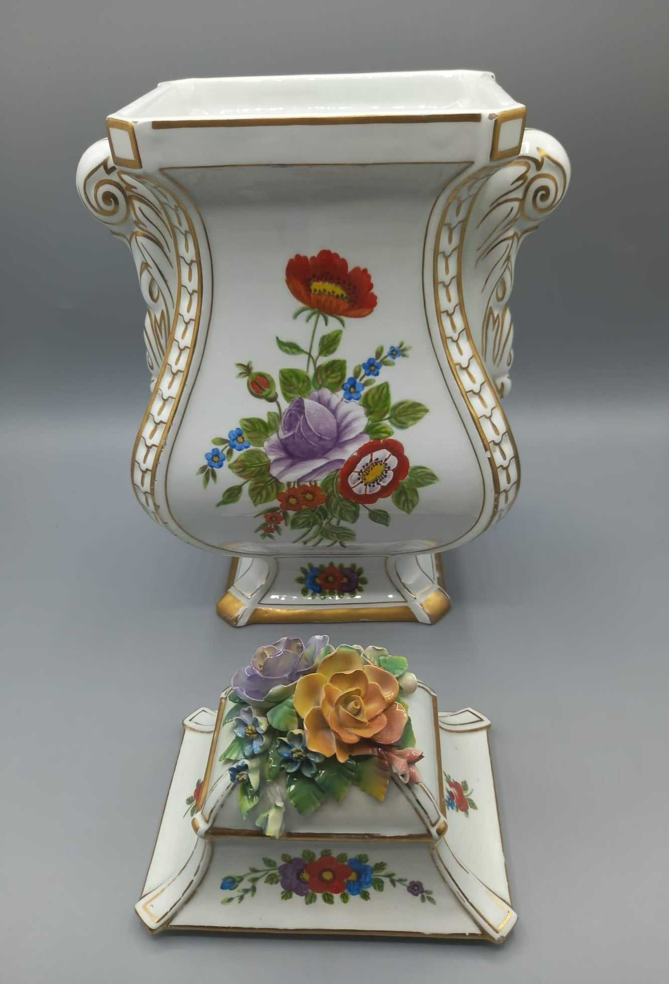 Jarrón de porcelana pintado con detalle floral, calidad superior, con tapa decorada con flores en relieve, ideal para decoración de interiores.