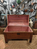 Interior forrado en tela rosa del baúl antiguo de madera de pino para ajuares de novia, perfecto para decoración vintage o guardarropa.