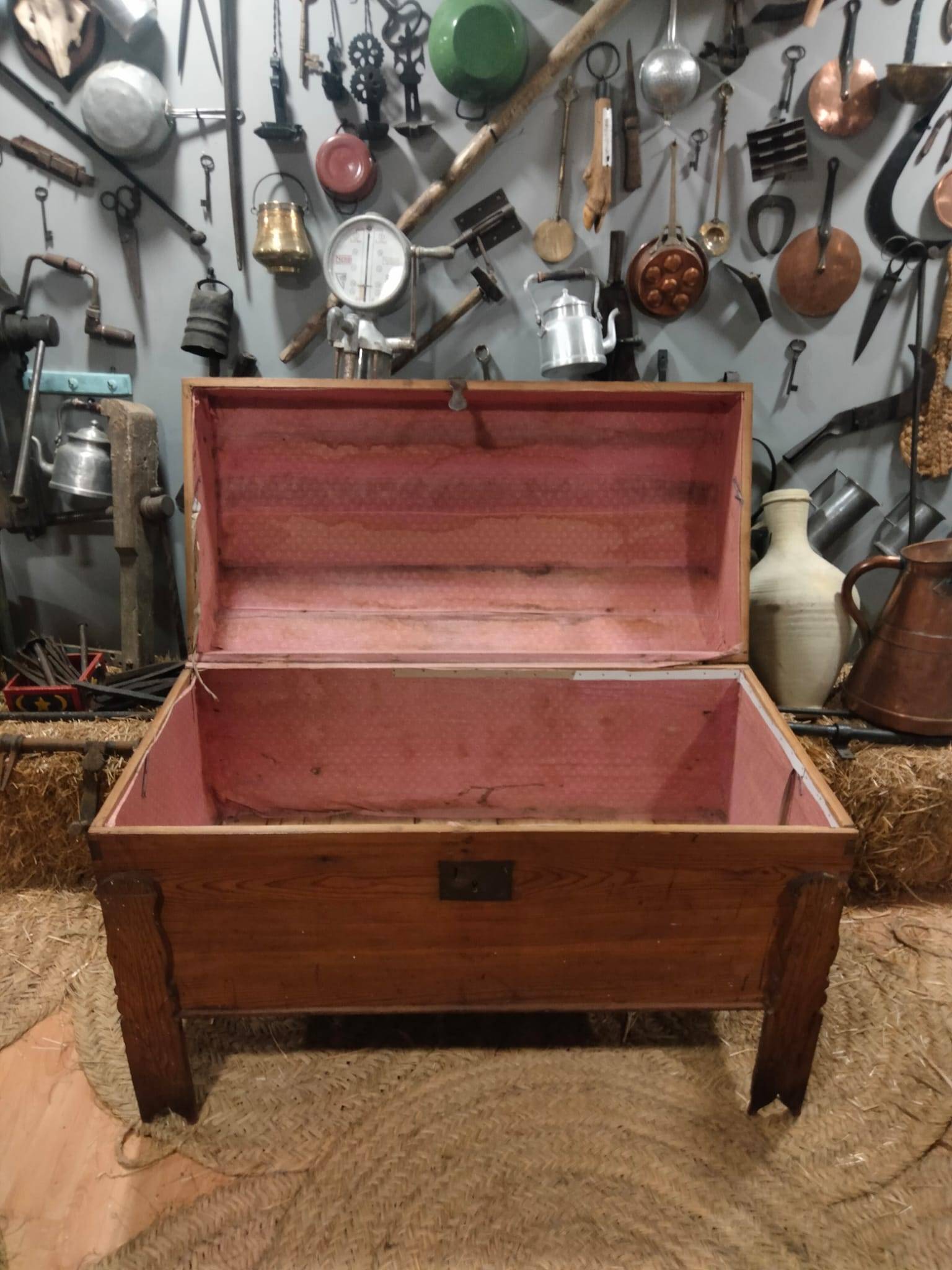 Interior forrado en tela rosa del baúl antiguo de madera de pino para ajuares de novia, perfecto para decoración vintage o guardarropa.