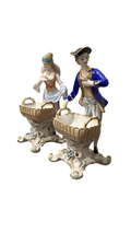 Figuras decorativas de hombre y mujer Sèvres con trajes del siglo XVIII y canastas, diseño ornamental para hogar elegante.