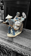 Lladró Paseo en China, figura de porcelana con geisha y conductor en rickshaw. Diseño artesanal para embellecer espacios con elegancia.