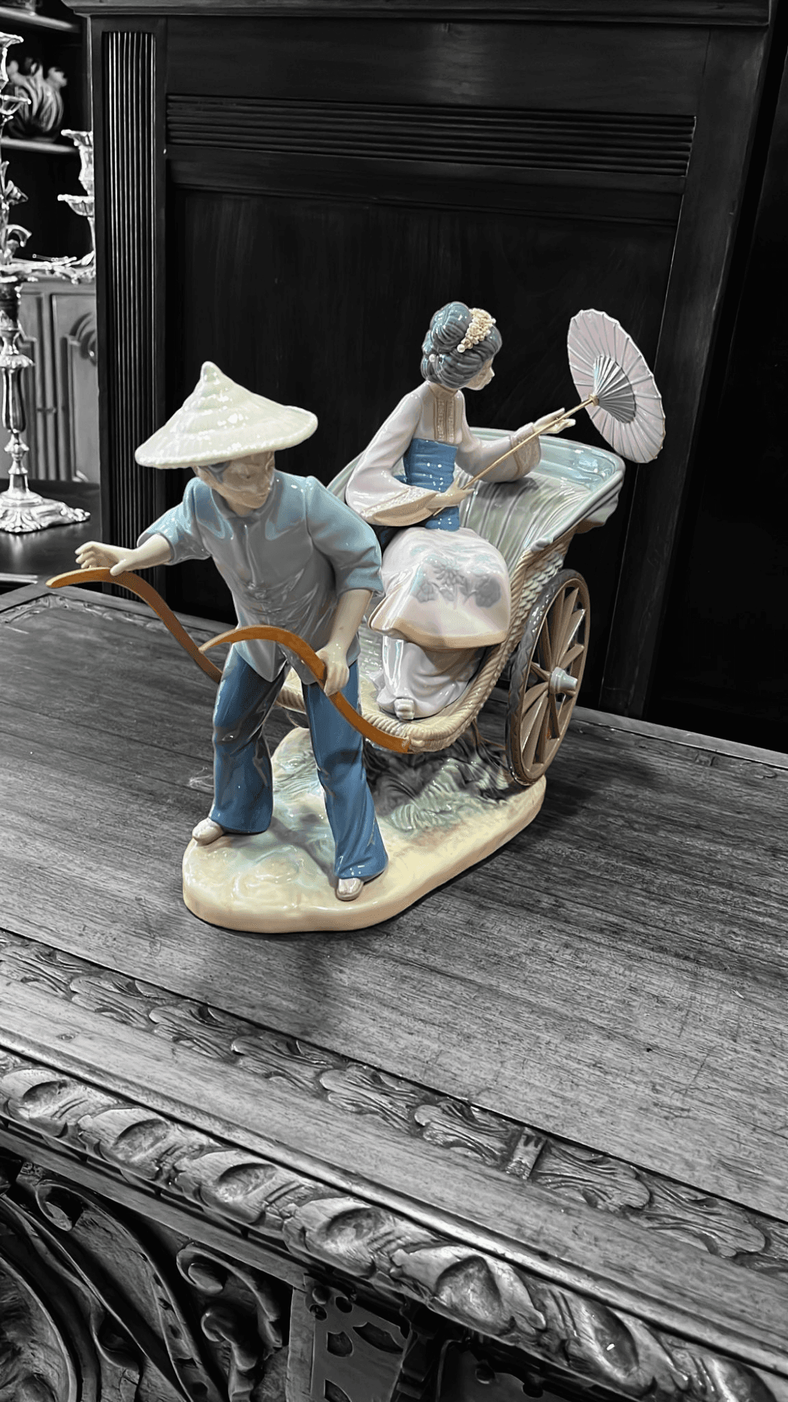 Lladró Paseo en China, figura de porcelana con geisha y conductor en rickshaw. Diseño artesanal para embellecer espacios con elegancia.