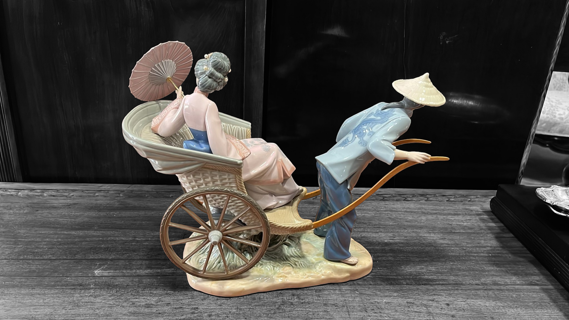 Escultura Lladró Paseo en China con geisha en carro tradicional, porcelana fina con acabados detallados. Ideal para decoración exclusiva.