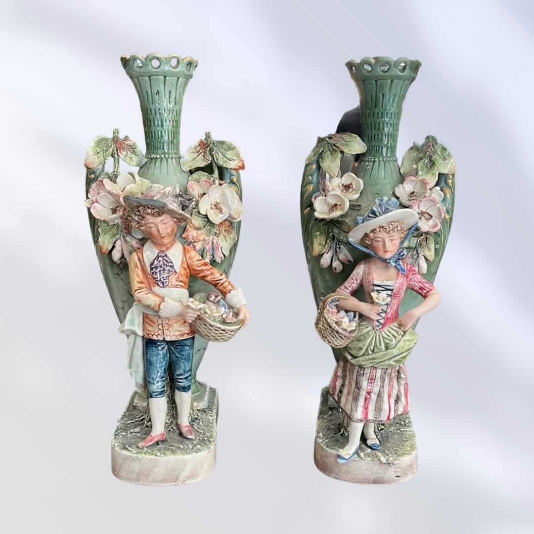 Exclusiva pareja de floreros de porcelana pintados a mano, con figuras de campesinos y detalles florales del siglo XIX.