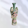 Florero de porcelana pintado a mano con figura de campesina, adornado con flores y diseño artístico del siglo XIX.