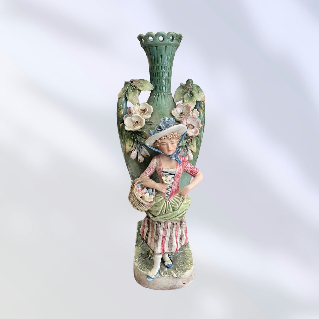 Florero de porcelana pintado a mano con figura de campesina, adornado con flores y diseño artístico del siglo XIX.