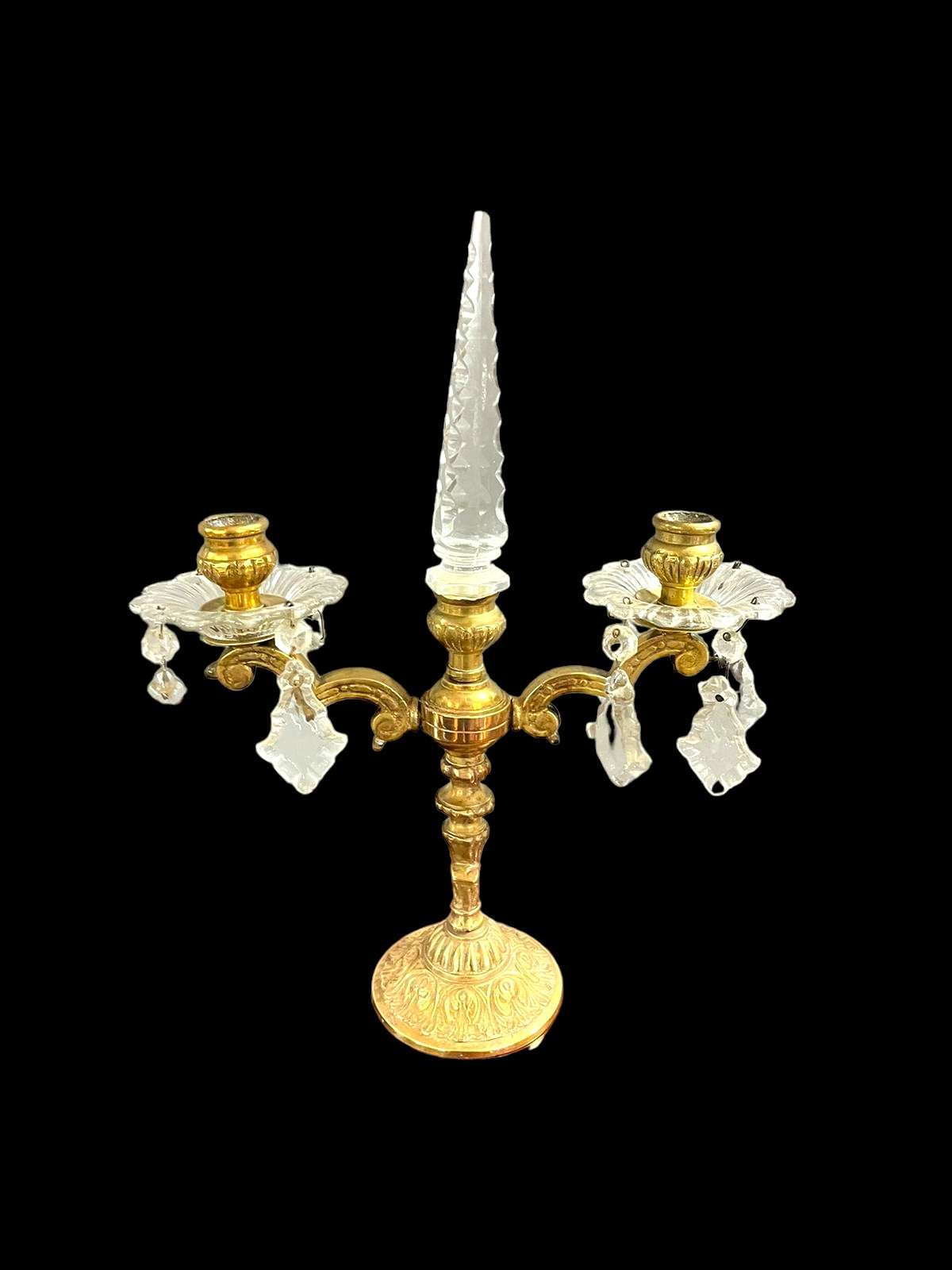 Candelabro antiguo de metal con detalles ornamentales y colgantes de cristal, diseño de principios del siglo XX para decoración vintage.