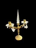 Candelabro decorativo antiguo de metal y cristal con diseño simétrico y pináculo central, ideal para ambientaciones de época en el hogar.