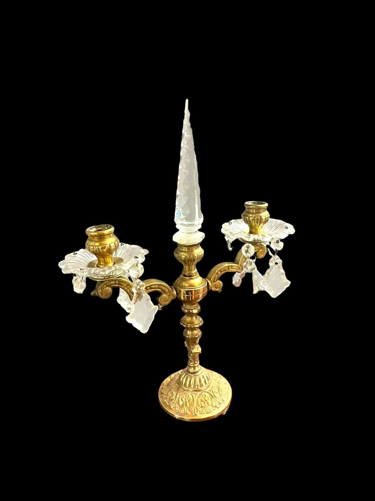 Candelabro decorativo antiguo de metal y cristal con diseño simétrico y pináculo central, ideal para ambientaciones de época en el hogar.