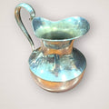 Jarra de metal estilo alpaca con alta capacidad y forma ergonómica, perfecta como aguamanil decorativo en espacios de hogar y jardín.