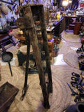 Criba antigua para separar aceitunas de impurezas, pieza vertical de madera con rejilla metálica, ideal para decoración rústica en hogar o jardín.