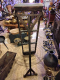 Criba antigua para separar aceitunas de impurezas, estructura de madera vertical con malla metálica, ideal como decoración rústica de hogar o jardín.