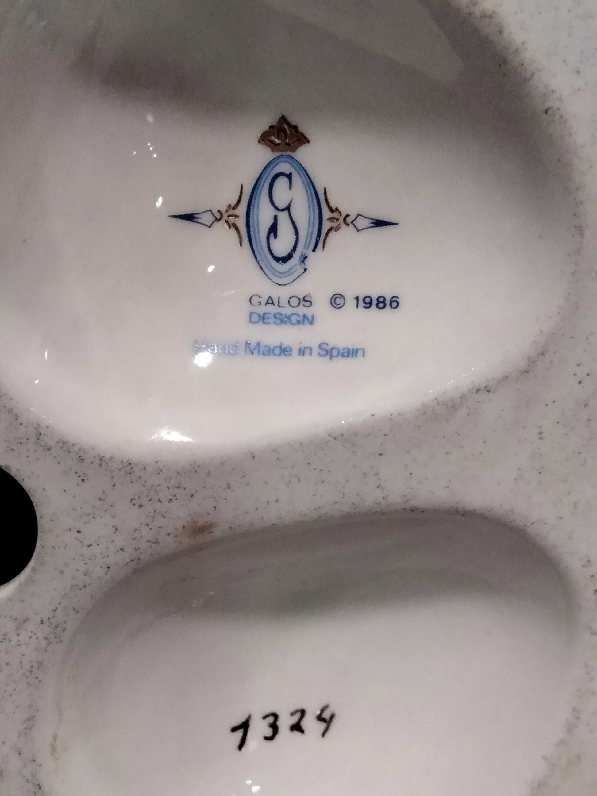 Sello Galos Design 1986 en la base de figura de porcelana Carlos, hecho a mano en España, autenticidad garantizada para coleccionistas.
