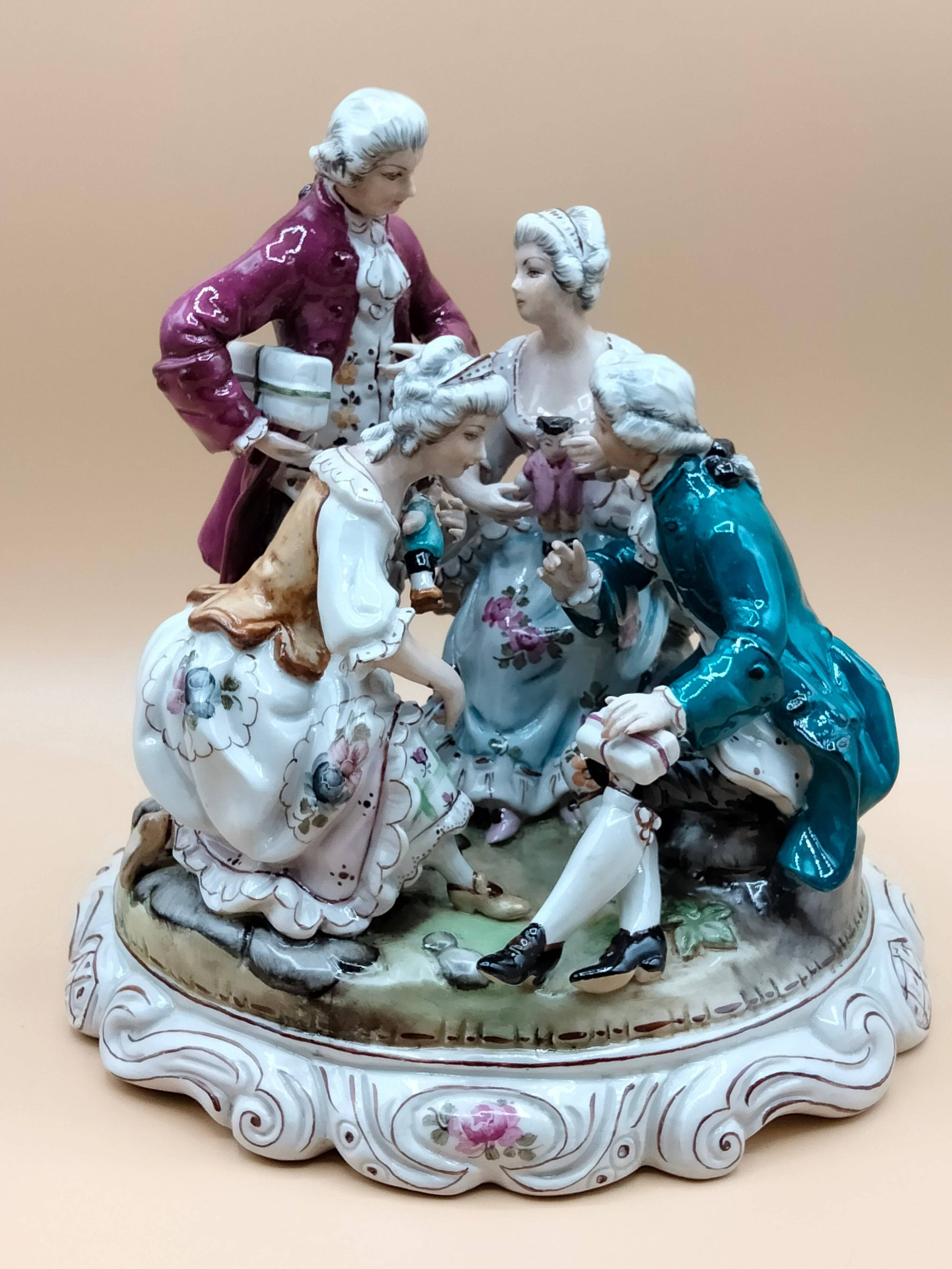 Escultura de porcelana SAUTHIER de los años 70, pintada a mano, muestra escena cortesana con detalles florales, perfecta para coleccionistas de decoración antigua.