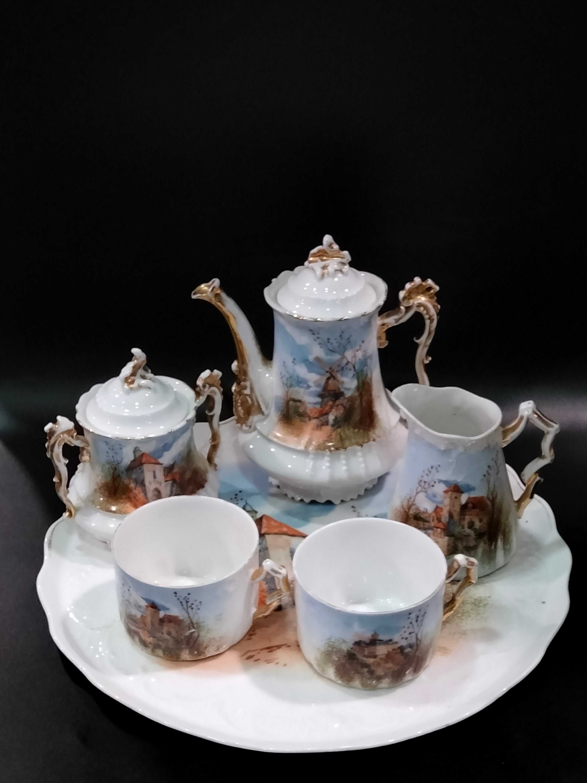 Juego de Café Tú y Yo de Porcelana Limoges, 1915-1934 completo con bandeja, tazas, tetera, azucarera y jarra, decorado a mano con paisajes rurales.