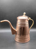 Cafetera de cobre con mango metálico decorada, estilo vintage, ideal para decoración artesanal en cocina o sala. Diseño árabe con grabados clásicos.