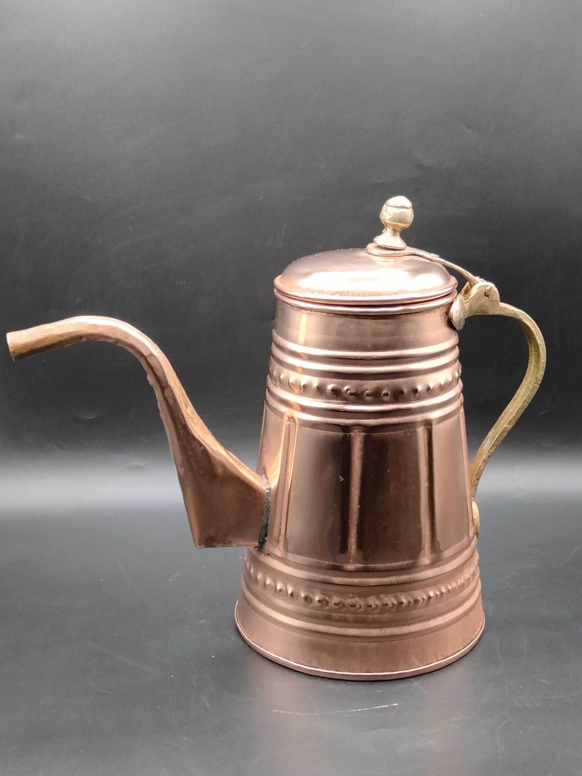 Cafetera de cobre con mango metálico decorada, estilo vintage, ideal para decoración artesanal en cocina o sala. Diseño árabe con grabados clásicos.