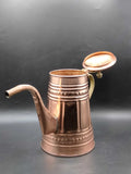 Cafetera de cobre con mango metálico, decorada con grabados artesanales y tapa abierta, ideal para decoración vintage en cocina o sala.