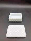 Caja joyero de opalina blanca con diseño en rombos, abierta con tapa al lado. Perfecta para guardar joyas con estilo clásico.